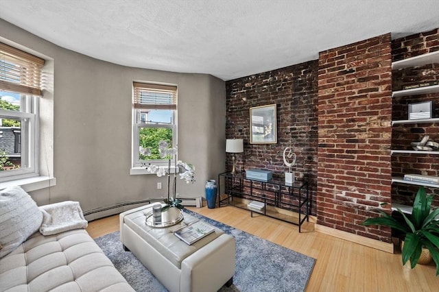 34 Beacon St Unit 3, Chelsea, MA 02150 - living room with wood finished floors, a baseboard radiator, a textured ceiling, and brick wall