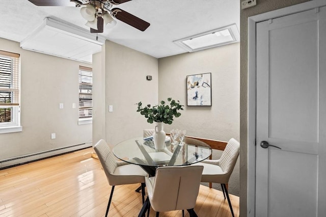 34 Beacon St Unit 3, Chelsea, MA 02150 - dining room with wood finished floors, a ceiling fan, a skylight, and a baseboard heating unit