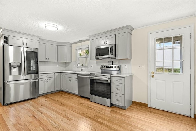 191 Franklin St Unit A, Stoneham, MA 02180 - kitchen featuring appliances with stainless steel finishes, gray cabinetry, light countertops, light wood-type flooring, and a textured ceiling
