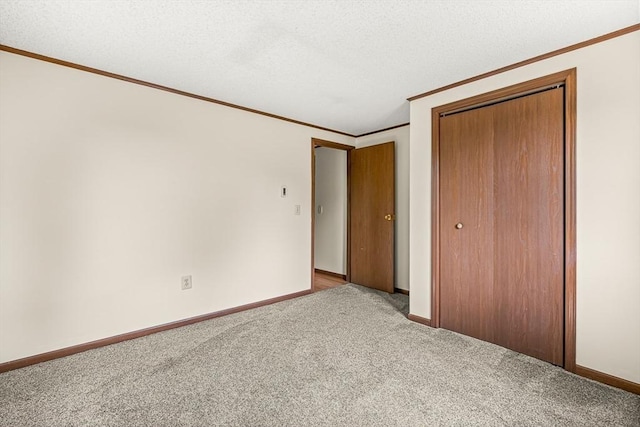 191 Franklin St Unit A, Stoneham, MA 02180 - unfurnished bedroom with ornamental molding, a closet, light colored carpet, a textured ceiling, and baseboards