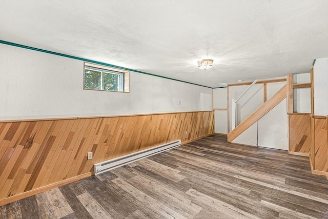 191 Franklin St Unit A, Stoneham, MA 02180 - below grade area with wooden walls, a baseboard radiator, wood finished floors, and a wainscoted wall