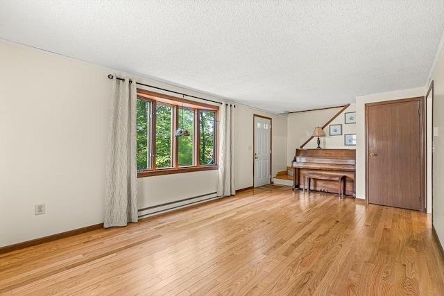 191 Franklin St Unit A, Stoneham, MA 02180 - foyer featuring baseboard heating, light wood-style floors, a textured ceiling, stairway, and baseboards