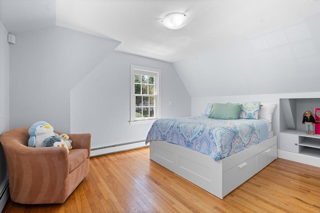 bedroom featuring lofted ceiling, baseboard heating, and light wood finished floors
