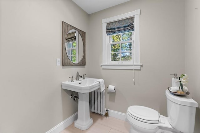 bathroom featuring toilet, baseboards, and radiator