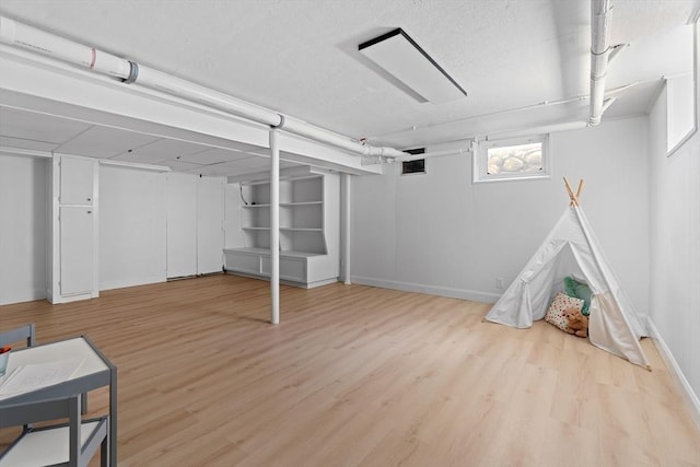 below grade area featuring baseboards and wood finished floors