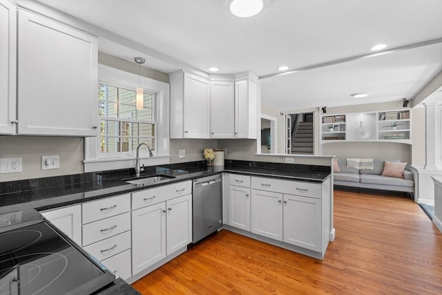 kitchen with stainless steel dishwasher, light wood-type flooring, a sink, white cabinets, and open floor plan
