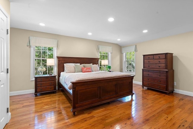 bedroom featuring baseboards, multiple windows, and light wood-type flooring