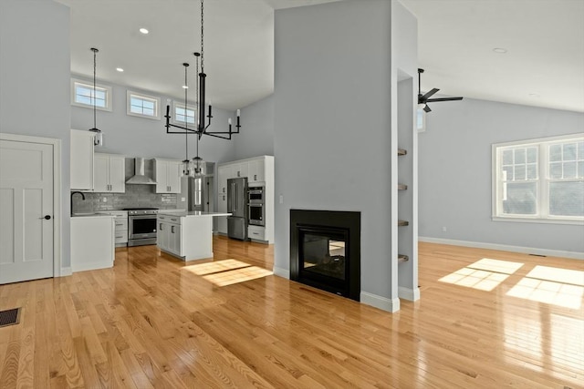 47 Spring St, Rehoboth, MA 02769 - unfurnished living room featuring high vaulted ceiling, light wood-style flooring, a chandelier, a ceiling fan, and recessed lighting