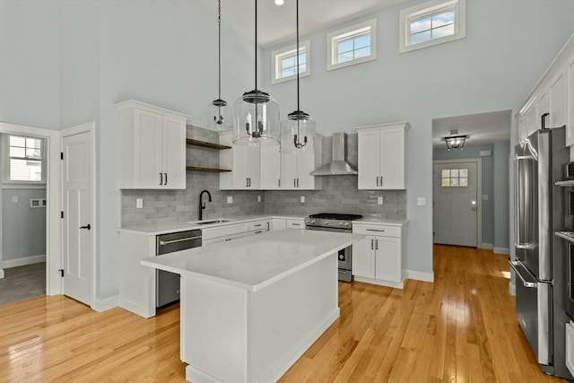 47 Spring St, Rehoboth, MA 02769 - kitchen with stainless steel appliances, wall chimney range hood, a high ceiling, a sink, and light countertops