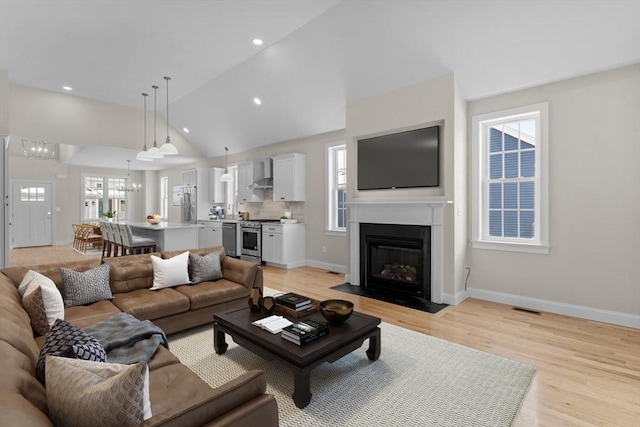 47 Spring St, Rehoboth, MA 02769 - living room with light wood-style flooring, baseboards, a fireplace with flush hearth, recessed lighting, and high vaulted ceiling