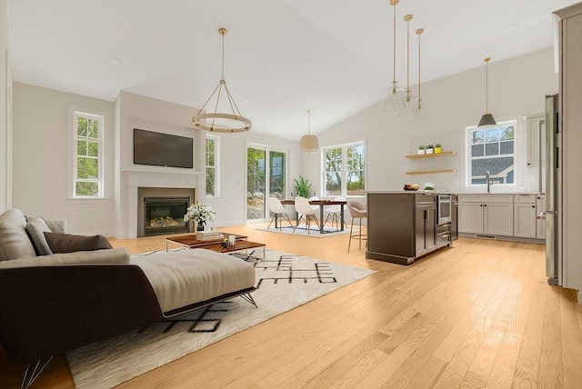 47 Spring St, Rehoboth, MA 02769 - living area featuring light wood-style floors, a glass covered fireplace, and lofted ceiling