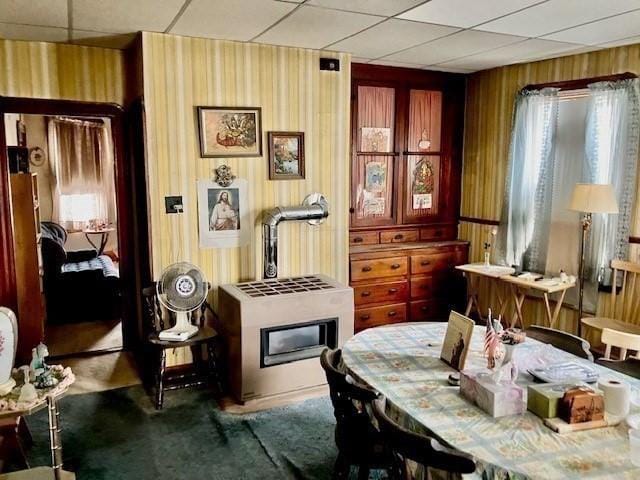 carpeted dining area featuring wooden walls