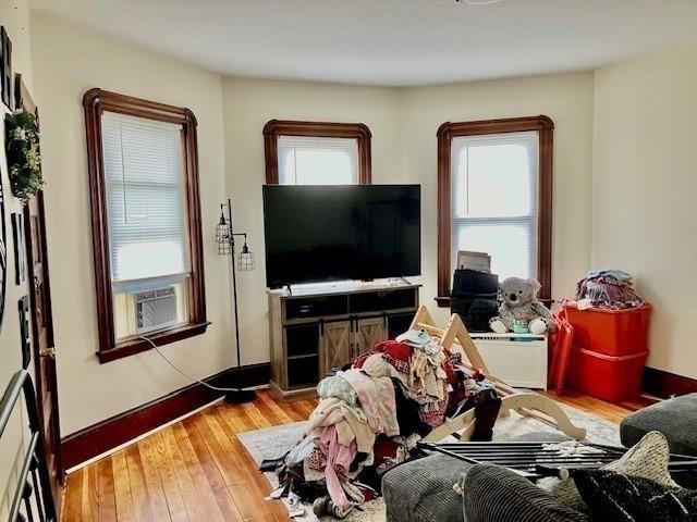 living room featuring cooling unit, plenty of natural light, and light wood-type flooring