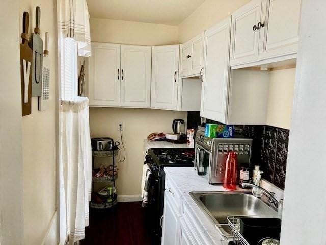 kitchen featuring white cabinetry, gas stove, and sink