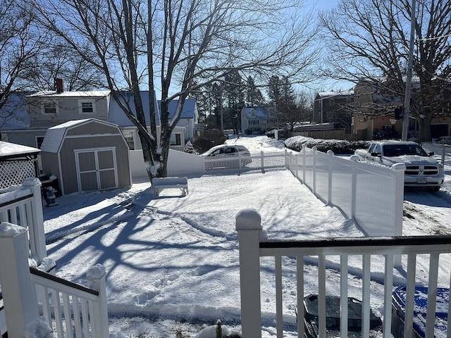 yard layered in snow with a storage unit