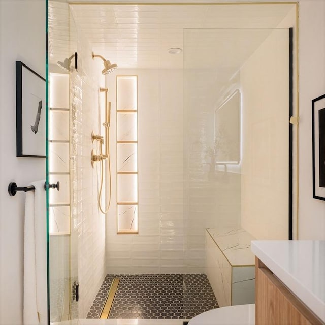 bathroom featuring vanity, toilet, and a tile shower