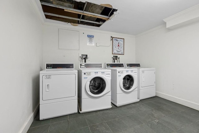 clothes washing area featuring washing machine and clothes dryer, crown molding, and dark tile patterned floors