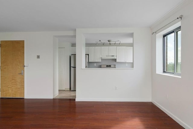 interior space with dark hardwood / wood-style flooring and plenty of natural light