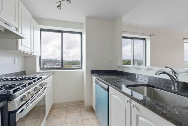kitchen featuring white cabinets, sink, dark stone countertops, stainless steel appliances, and extractor fan
