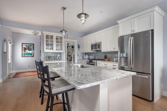 kitchen featuring a center island with sink, white cabinets, and appliances with stainless steel finishes