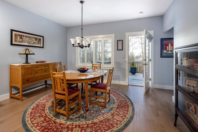 dining space featuring hardwood / wood-style flooring and a chandelier