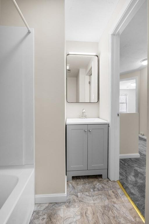 full bath with a bath, walk in shower, vanity, and baseboards