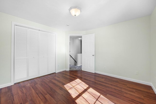 unfurnished bedroom with a closet, baseboards, and wood finished floors