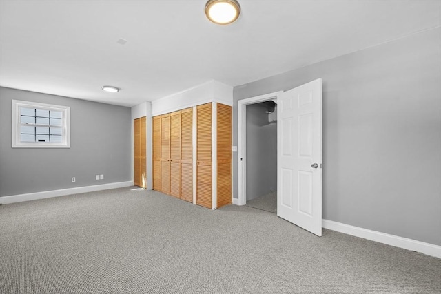 unfurnished bedroom with a closet, carpet flooring, and baseboards