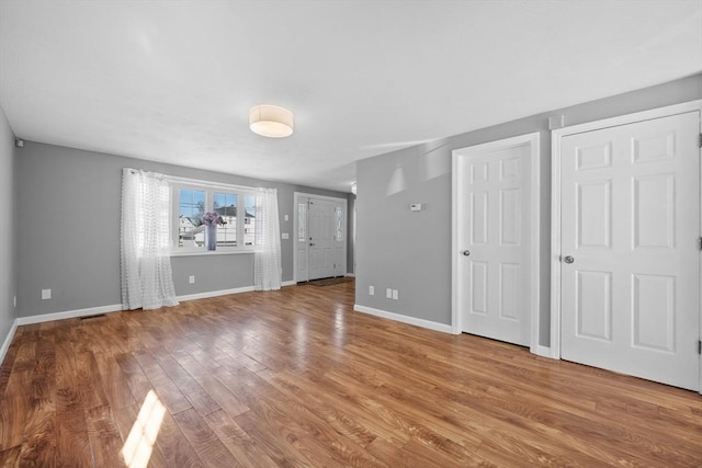 interior space with wood finished floors, visible vents, and baseboards