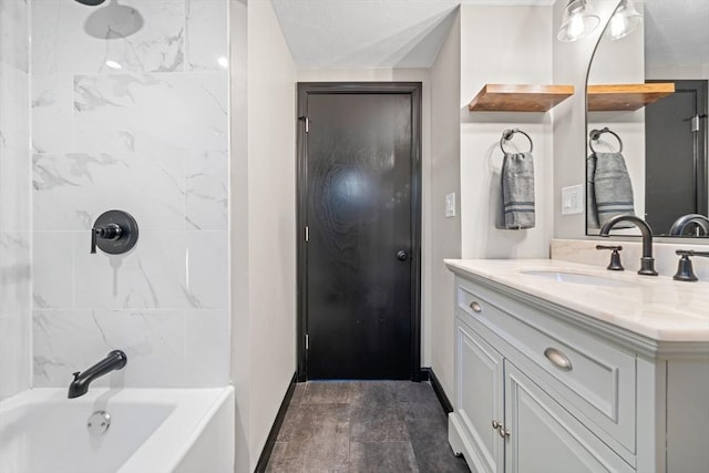 bathroom featuring baseboards, vanity, and bathtub / shower combination
