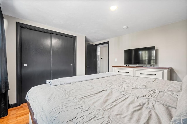 bedroom with light wood-type flooring and a closet