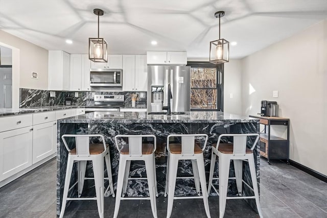 kitchen featuring appliances with stainless steel finishes, a center island, recessed lighting, dark stone countertops, and white cabinets