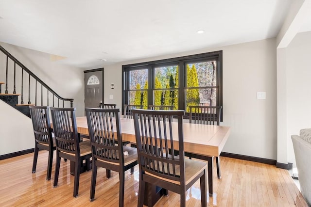 dining space with light wood finished floors, baseboards, stairs, and recessed lighting
