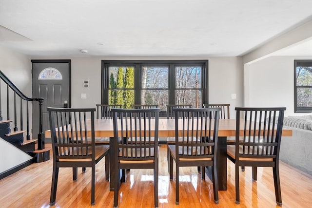 dining area with light wood-style floors and stairway