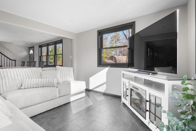 living room with baseboards, stairs, and tile patterned flooring