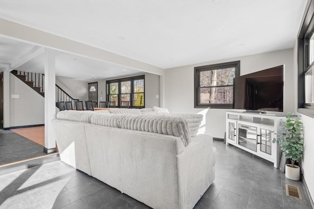 living area featuring stairs and baseboards