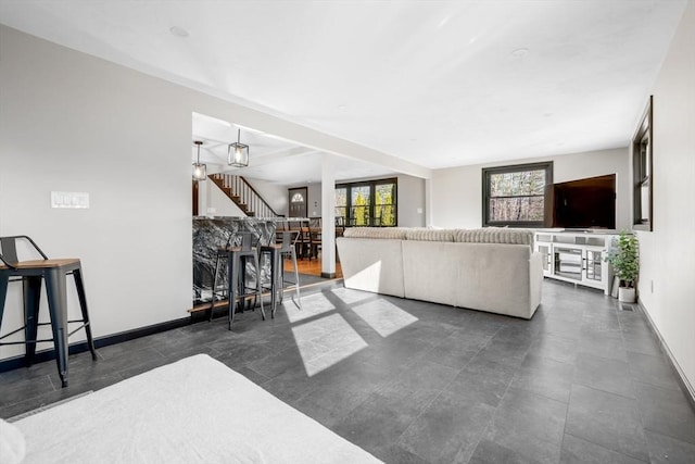 living area with baseboards and stairway