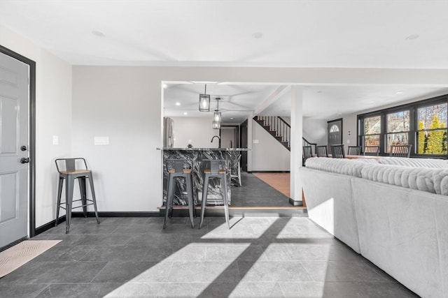 living area featuring stairway, baseboards, recessed lighting, and bar area