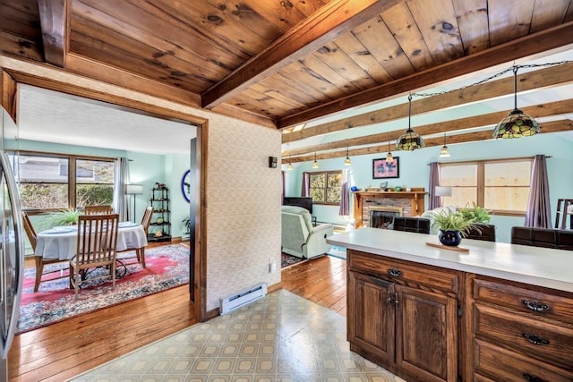 67 Whippoorwill Cir, Mashpee, MA 02649 - kitchen featuring baseboard heating, light countertops, a fireplace, wooden ceiling with exposed beams, and decorative light fixtures
