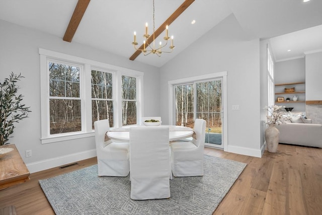 dining area featuring beam ceiling, light wood-type flooring, visible vents, and a notable chandelier