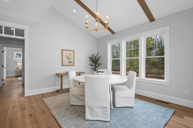 dining area with baseboards, a chandelier, and light wood-style floors