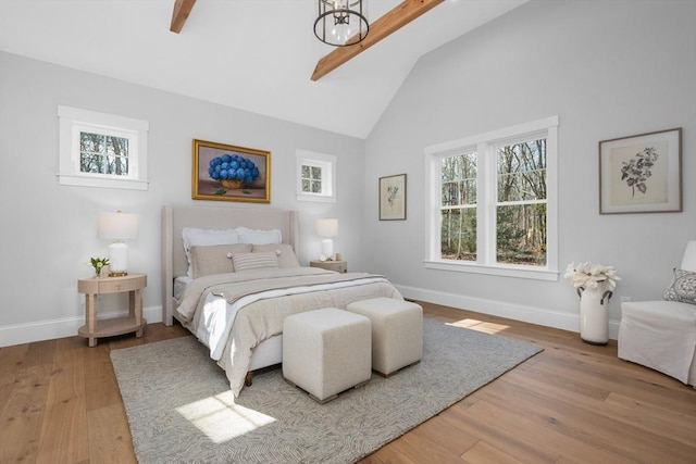 bedroom with high vaulted ceiling, baseboards, and wood finished floors