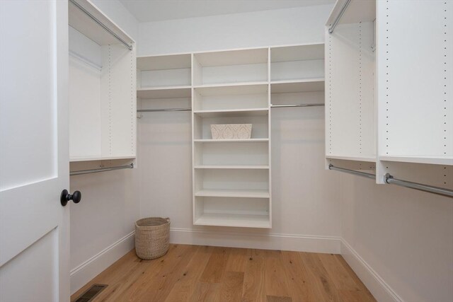 walk in closet featuring light wood-type flooring and visible vents