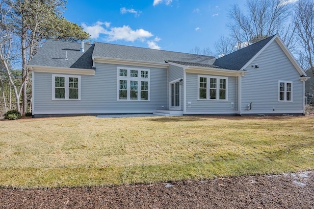 back of house with a shingled roof and a yard