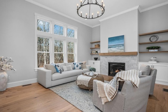 living room with ornamental molding, light wood finished floors, and baseboards