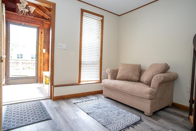 22 Everton Ave, Worcester, MA 01604 - living area with wood finished floors, baseboards, ornamental molding, healthy amount of natural light, and a chandelier