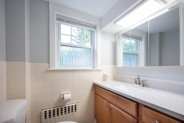 203 Pond St, Weymouth, MA 02190 - bathroom with radiator heating unit, toilet, healthy amount of natural light, tile walls, and a wainscoted wall