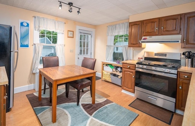 203 Pond St, Weymouth, MA 02190 - kitchen featuring stainless steel appliances, under cabinet range hood, light countertops, light wood-style floors, and baseboards