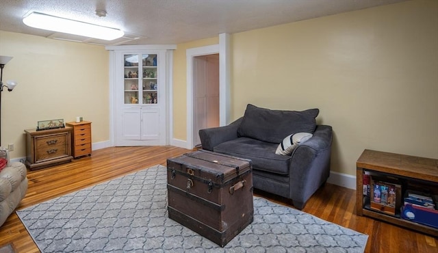 203 Pond St, Weymouth, MA 02190 - living area featuring wood finished floors, baseboards, and a textured ceiling