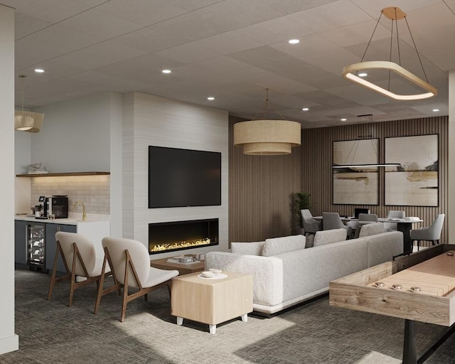carpeted living room with recessed lighting, a fireplace, beverage cooler, and bar
